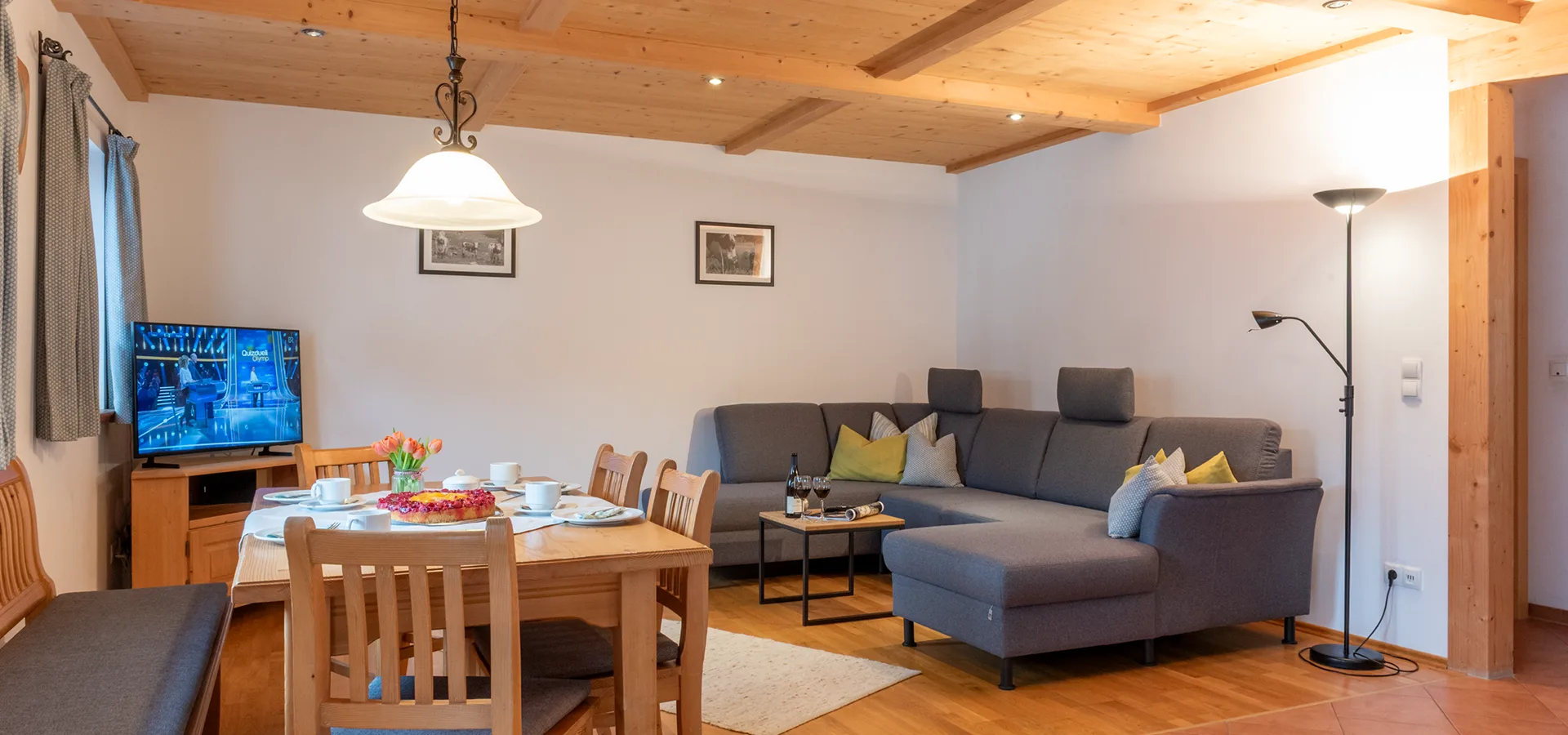 Ferienwohnung Amselnest mit Blick auf mit Kaffee und Kuchen eingedeckten Tisch und dahinter liegenden Couch
